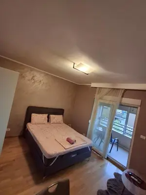 a bedroom with a bed in a room with a window at Apartman City Kvart Podgorica in Podgorica