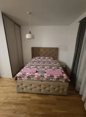 a bedroom with a bed with a quilt on it at Apartman City Kvart Podgorica in Podgorica