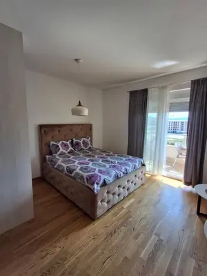 a bedroom with a bed and a large window at Apartman City Kvart Podgorica in Podgorica