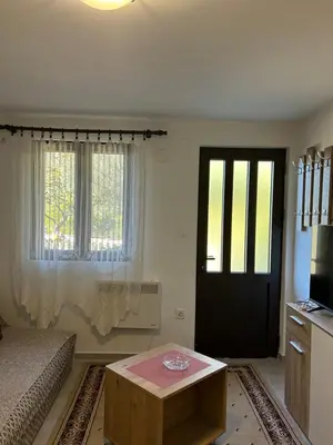 a room with a bed and a door and a table at Midpoint in Kotor