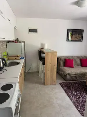 a kitchen and living room with a couch and a table at Midpoint in Kotor