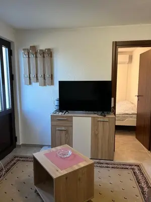 a living room with a flat screen tv and a table at Midpoint in Kotor