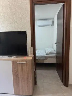 a room with a television and a small bedroom at Midpoint in Kotor