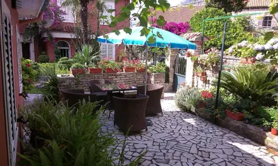 a garden with a table and an umbrella and plants at Apartment City Garden in Kotor
