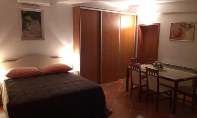 a bedroom with a bed and a table and a desk at Apartment City Garden in Kotor