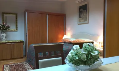 a bedroom with a bed and a vase of flowers on a table at Apartment City Garden in Kotor