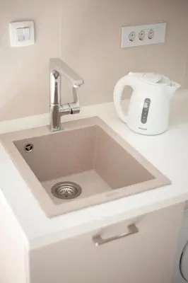 a sink in a white counter with a mixer at Pržno Bay in Sveti Stefan
