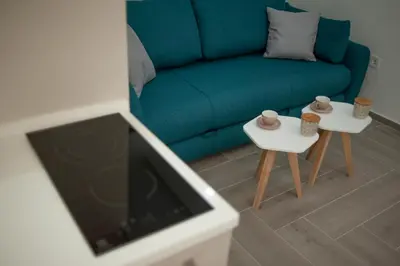 a living room with a blue couch and two tables at Pržno Bay in Sveti Stefan