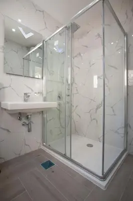 a bathroom with a glass shower and a sink at Pržno Bay in Sveti Stefan