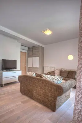 a living room with a couch and a television at Pržno Bay in Sveti Stefan