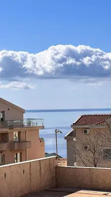 a view of the ocean from a city with buildings at Orhid apartment Becici one in Budva