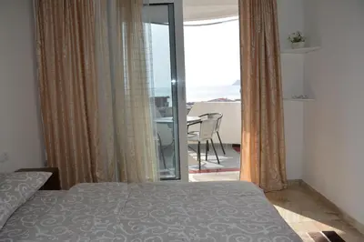 a bedroom with a bed and a view of a balcony at Studios Seaview in Dobra Voda