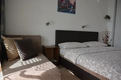 a small bedroom with a bed and a chair at Studios Seaview in Dobra Voda