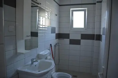 a bathroom with a sink and a toilet and a window at Studios Seaview in Dobra Voda