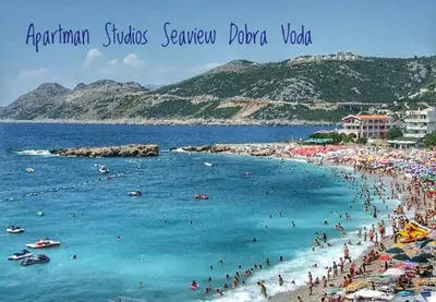 a beach with a bunch of people in the water at Studios Seaview in Dobra Voda