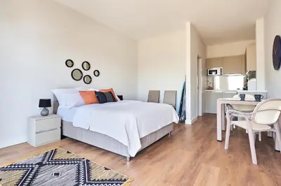 a bedroom with a bed and a desk and a kitchen at Casa Collection in Tivat