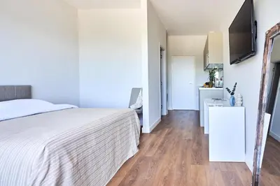 a bedroom with a bed and a television on a wall at Casa Collection in Tivat