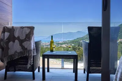 a table with a bottle of wine and two chairs at Casa Collection in Tivat