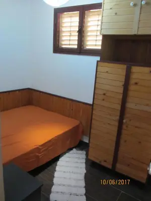 a bedroom with two beds and a dresser and two windows at Holiday Home Idyllic Cottage in Čanj
