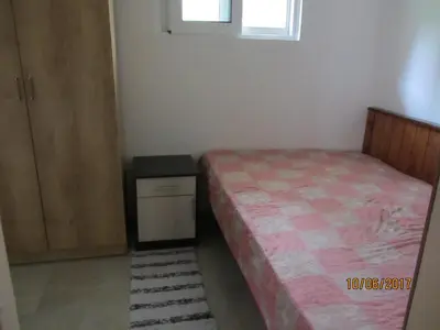 a small bedroom with a bed and a night stand at Holiday Home Idyllic Cottage in Čanj
