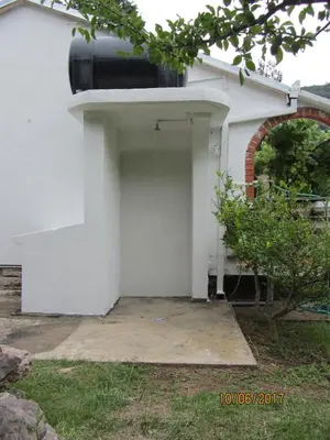 a garage with a tank on the side of a house at Holiday Home Idyllic Cottage in Čanj