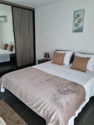 a bedroom with a large white bed and a mirror at Apartmani Sutomore Tri Palme in Sutomore