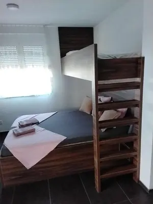 a bedroom with a bunk bed and a window at Apartmani Sutomore Tri Palme in Sutomore
