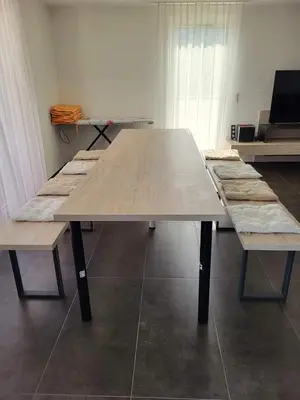 a large wooden table with benches in a room at Apartmani Sutomore Tri Palme in Sutomore