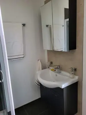 a bathroom with a sink and a mirror at Apartmani Sutomore Tri Palme in Sutomore