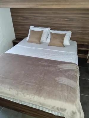 a large bed with white sheets and pillows at Apartmani Sutomore Tri Palme in Sutomore