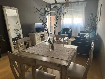 a living room with a table with a vase on it at NADJA Apartman City Kvart in Kruševac