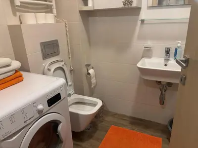 a bathroom with a washing machine and a sink at NADJA Apartman City Kvart in Kruševac