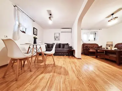 a living room with a table and chairs and a couch at Melody apartment in Podgorica