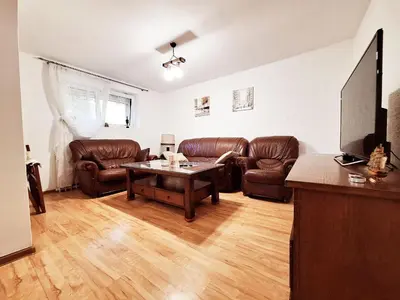 a living room with leather furniture and a table at Melody apartment in Podgorica
