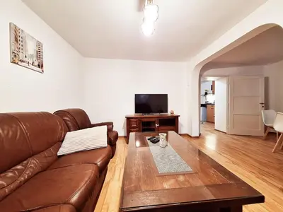 a living room with a brown leather couch and a table at Melody apartment in Podgorica