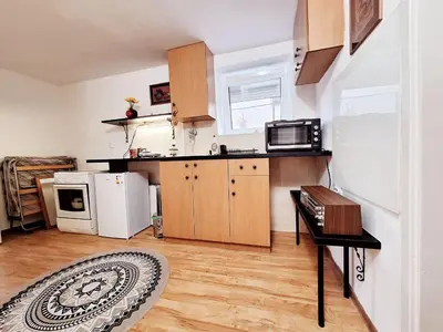 a kitchen with wooden cabinets and a white refrigerator at Melody apartment in Podgorica