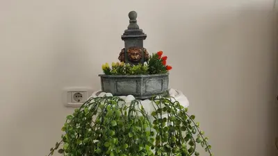 a flower pot with a statue on top of it at Allurian Apartment - City kvart in Podgorica