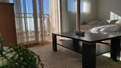 a room with a table and a bed and a mirror at Allurian Apartment - City kvart in Podgorica