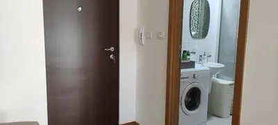 a bathroom with a washing machine and a sink at Allurian Apartment - City kvart in Podgorica