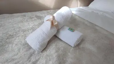 a pair of towels sitting on top of a bed at Allurian Apartment - City kvart in Podgorica
