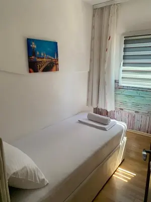 a white bed in a room with a window at Budva apartman Centar in Budva