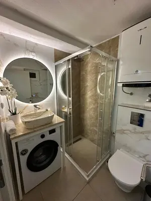 a bathroom with a shower and a washing machine at Budva apartman Centar in Budva