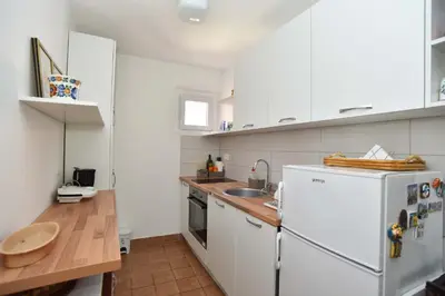 a kitchen with white cabinets and a white refrigerator at OLD TOWN 5 apartment in Budva