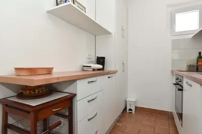 a kitchen with white cabinets and a wooden counter at OLD TOWN 5 apartment in Budva