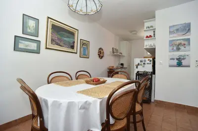 a dining room with a white table and chairs at OLD TOWN 5 apartment in Budva