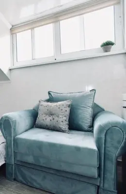 a blue couch with pillows sitting under a window at Budva OLD TOWN 4 apartment in Budva