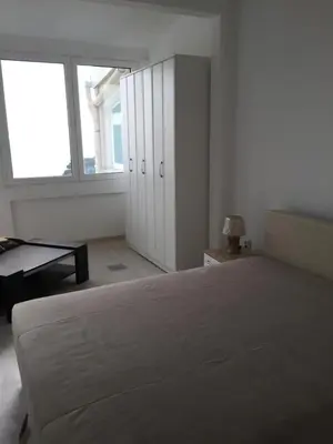 a white bedroom with a large bed and a window at Oro Apartments in Petrovac na Moru
