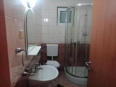 a bathroom with a toilet and a shower and a sink at Guest House Garden in Budva