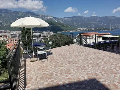 a patio with a table and an umbrella at Guest House Garden in Budva