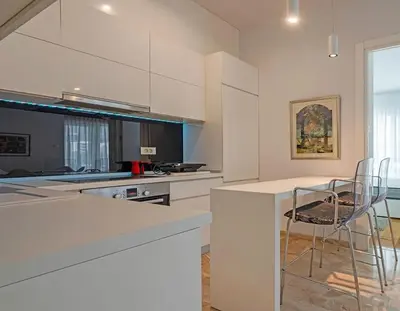 a kitchen with white cabinets and a bar with chairs at PREMIUM Tre canne apart 